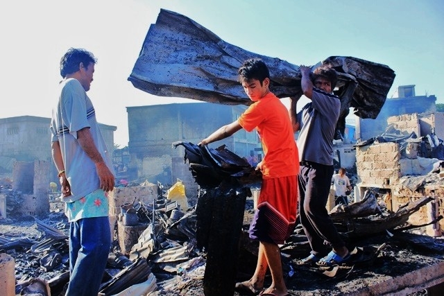 SALVAGE. Villagers salvage whatever they can at what used to be their home in San Isidro Labrador, Lapasan. The community was destroyed by fire on Friday night. (PHOTO BY NITZ ARANCON)